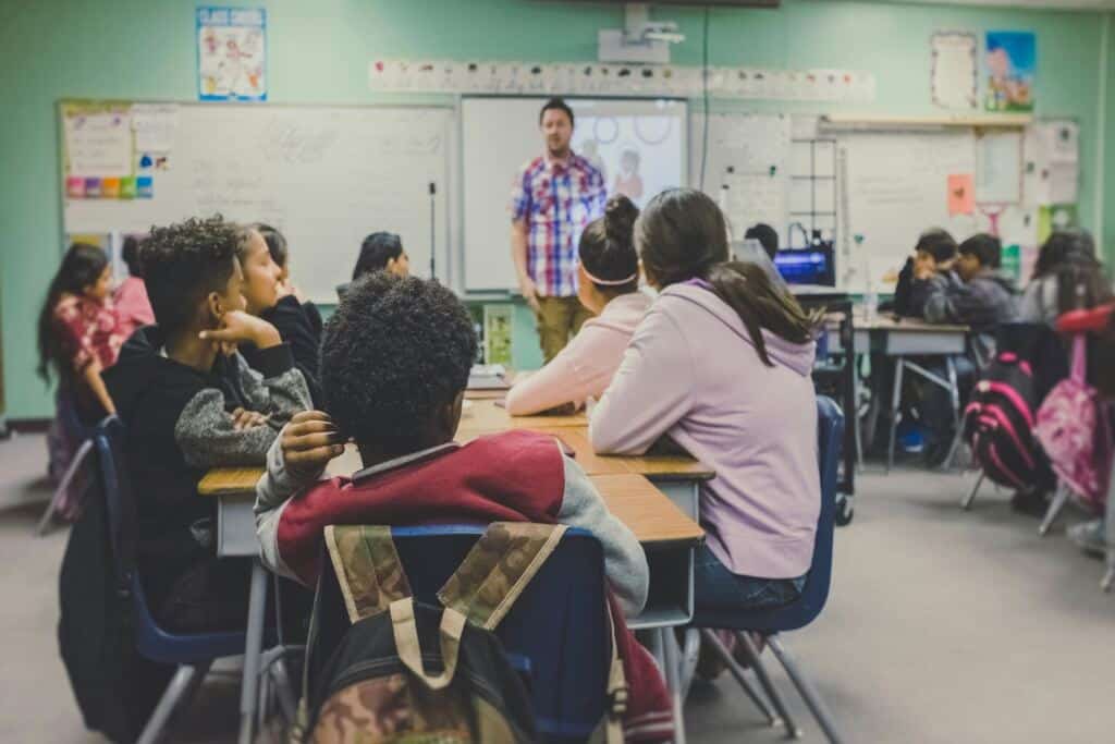 Schüler sitzen in einem Klassenraum. Der Unterricht kann dank der Schulsoftware von DigitalCheckIn reibungslos durchgeführt werden.